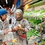 Middle Eastern couple shopping together for fresh vegetables in a supermarket produce aisle.